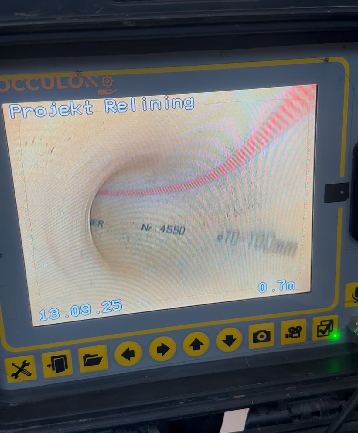 Worker installing blue pipes in excavated area